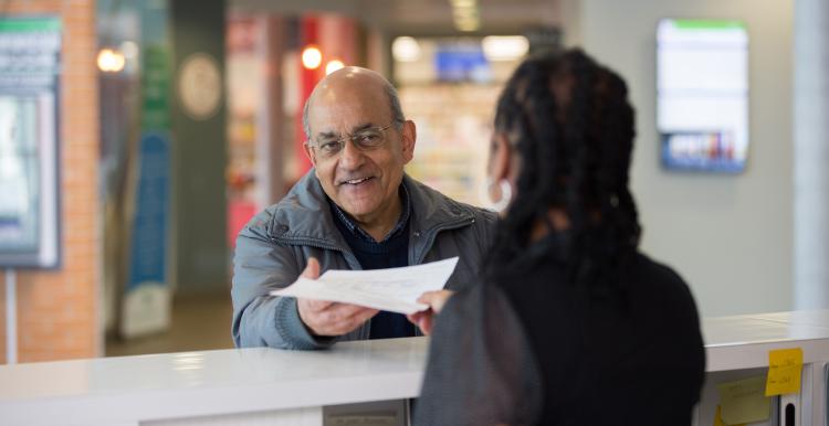 elderly man talking to receptionist