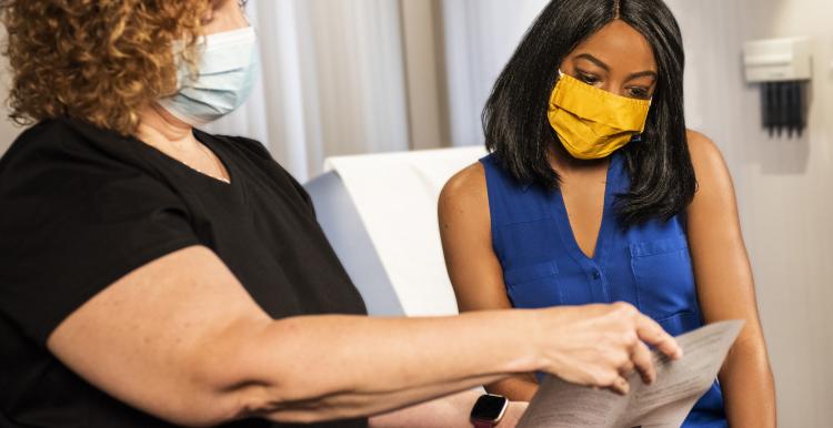 two women looking at vaccine leaflet 