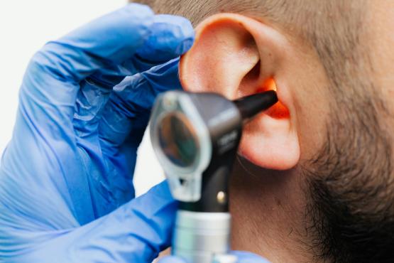 Doctor examines man's ear