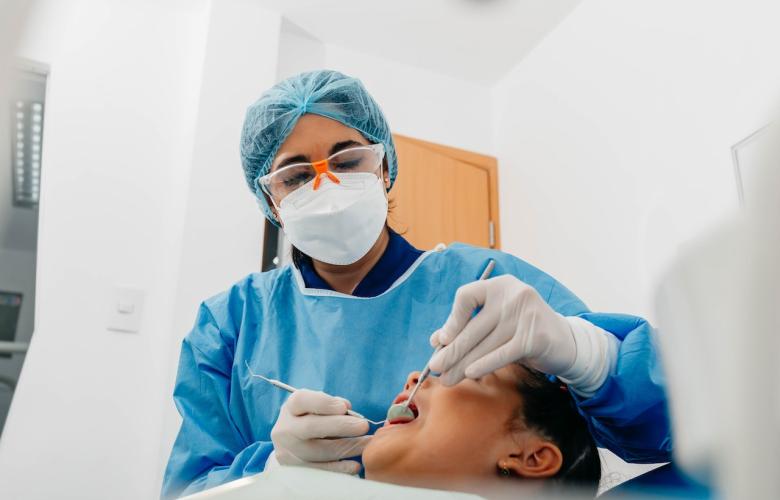 Dentist examines patient's teeth